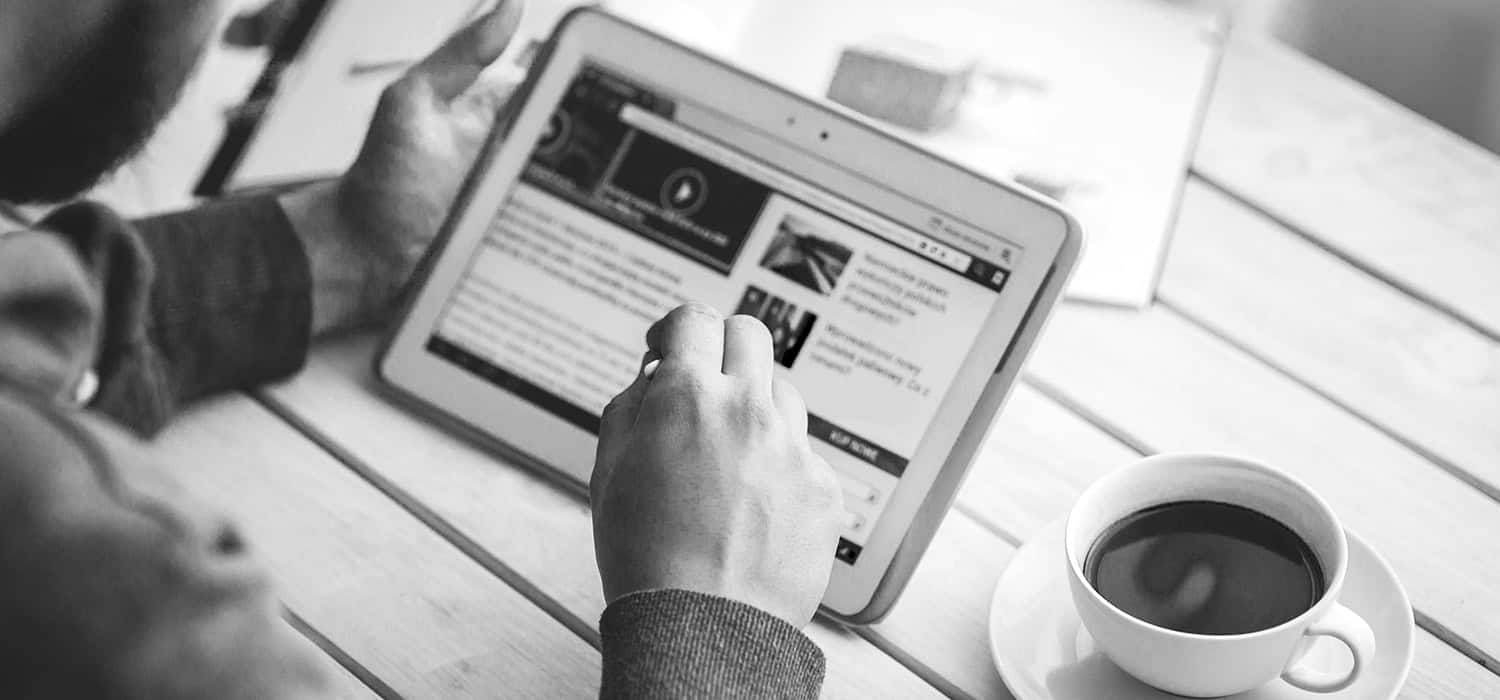 black and white photo of man using tablet